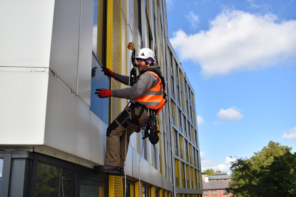 Person in harness working on a window