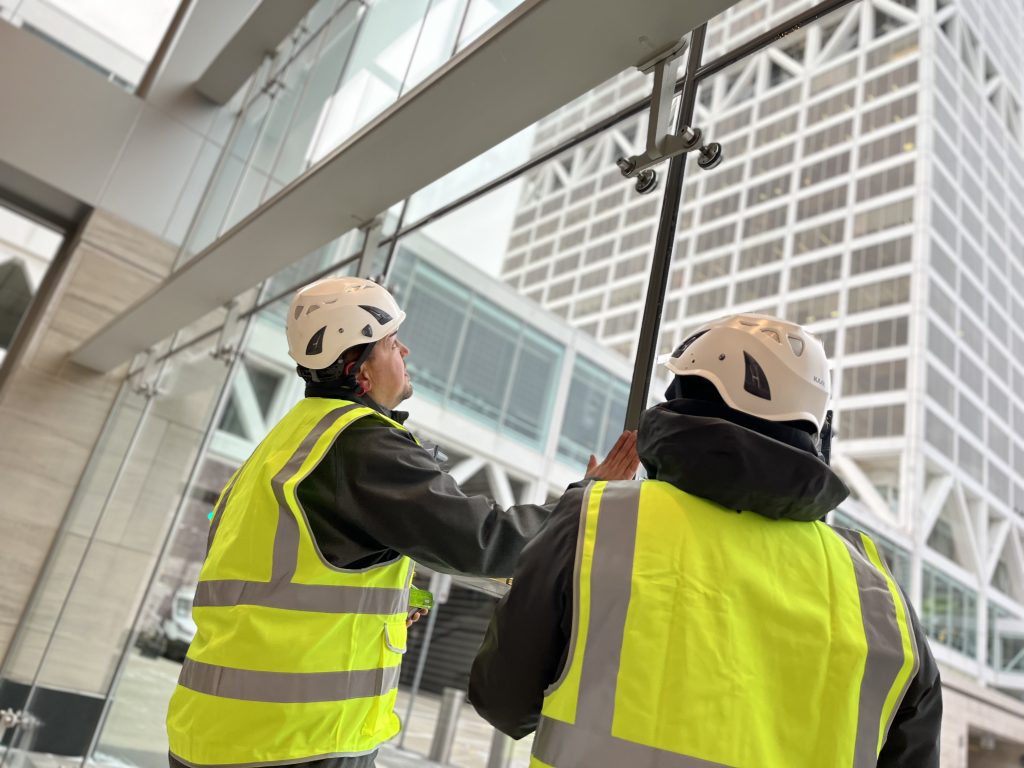 Construction workers installing glass panels